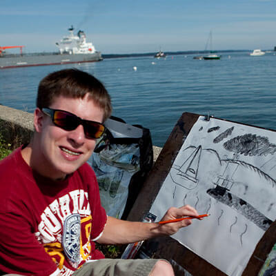art-student-drawing-by-the-beach-SMCC-Maine